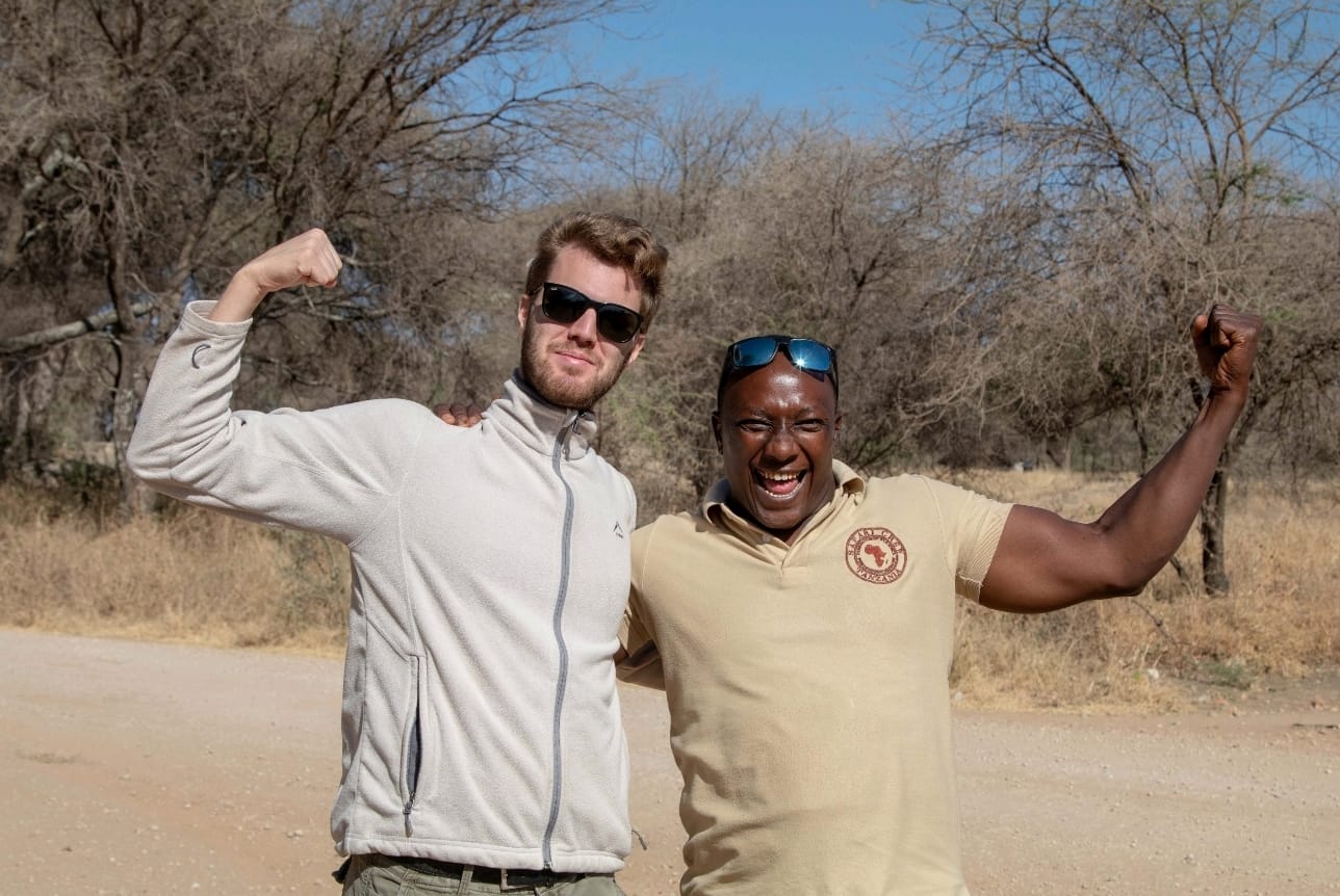Professional Tanzanian safari guide pointing out wildlife during Big Five game drive in Serengeti National Park